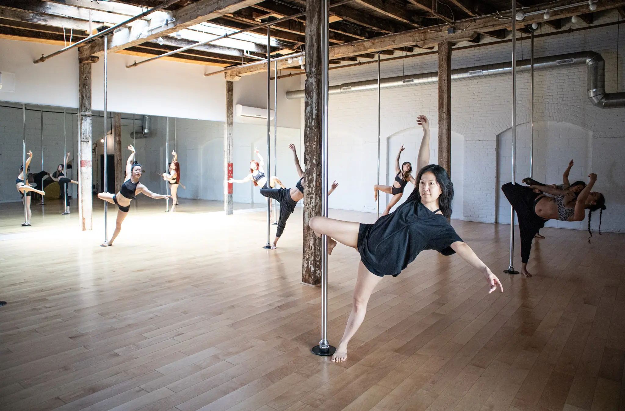 An instructor working one-to-one with a student on the pole