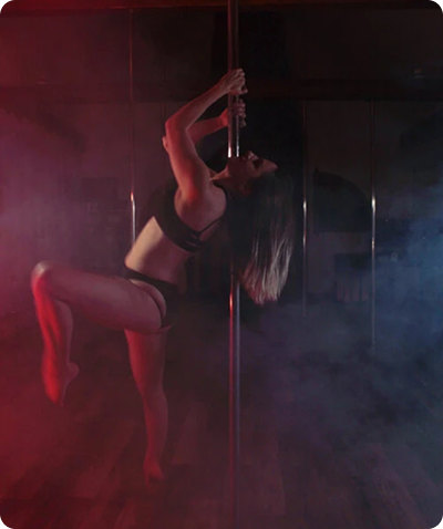 A dancer on the pole lit in deep red with haze