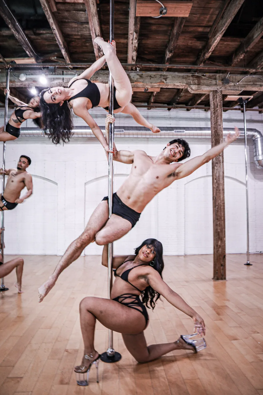 A student caught mid-spin on the pole in the daylight loft